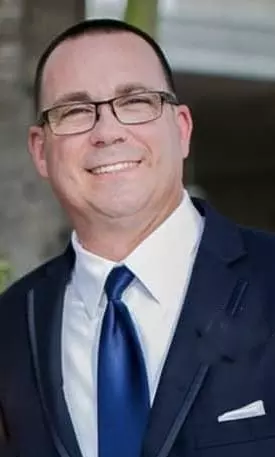 Photo of new fire chief wearing suit and tie.