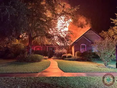 image of large home with fire coming from the roof