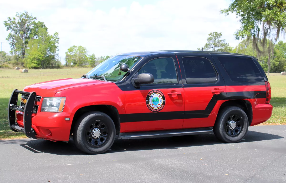 Photo of a black over red SUV with the High Springs Fire Dept. seal on the door.